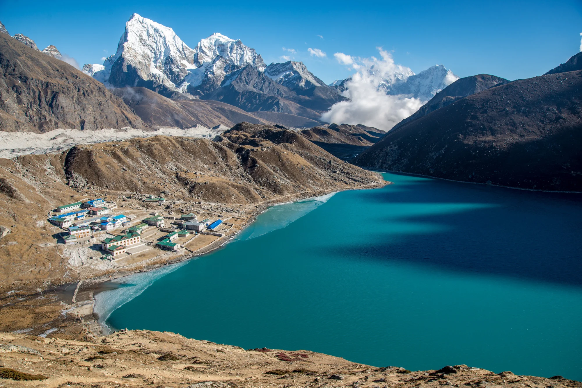 A tranquil mountain lake surrounded by towering peaks, showcasing the beauty of nature's landscape.
                